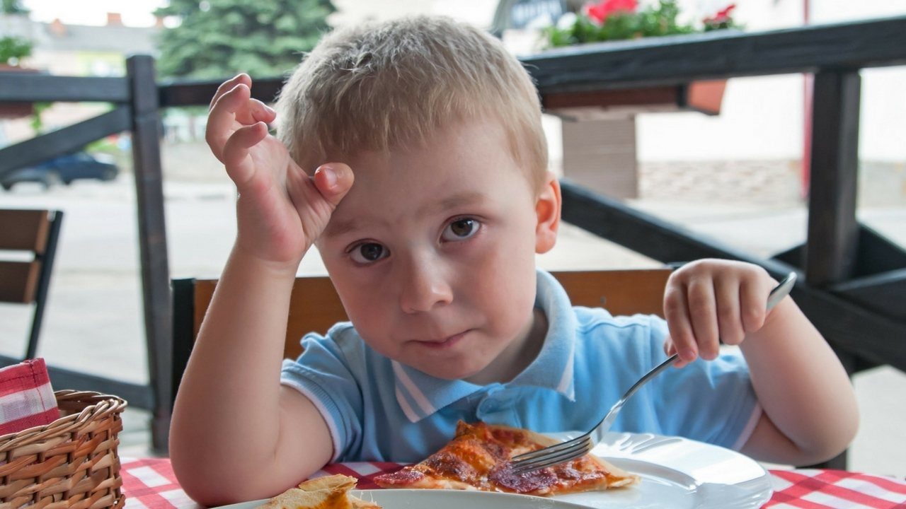 little boy eating pizza