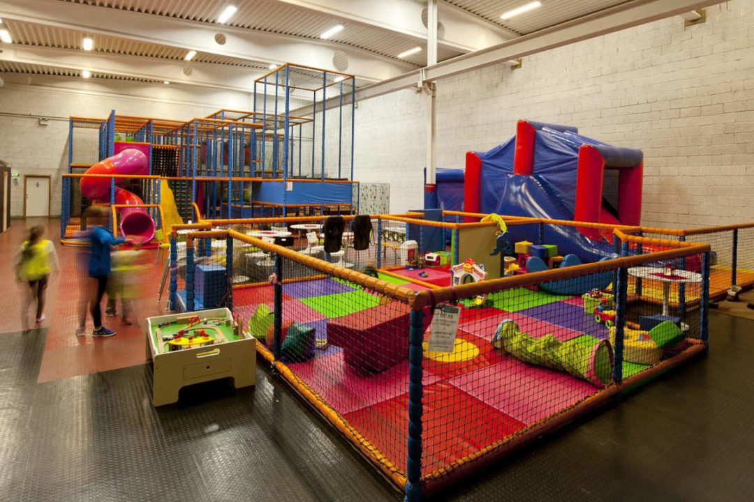 indoor playroom with jungle gym and inflatable castle