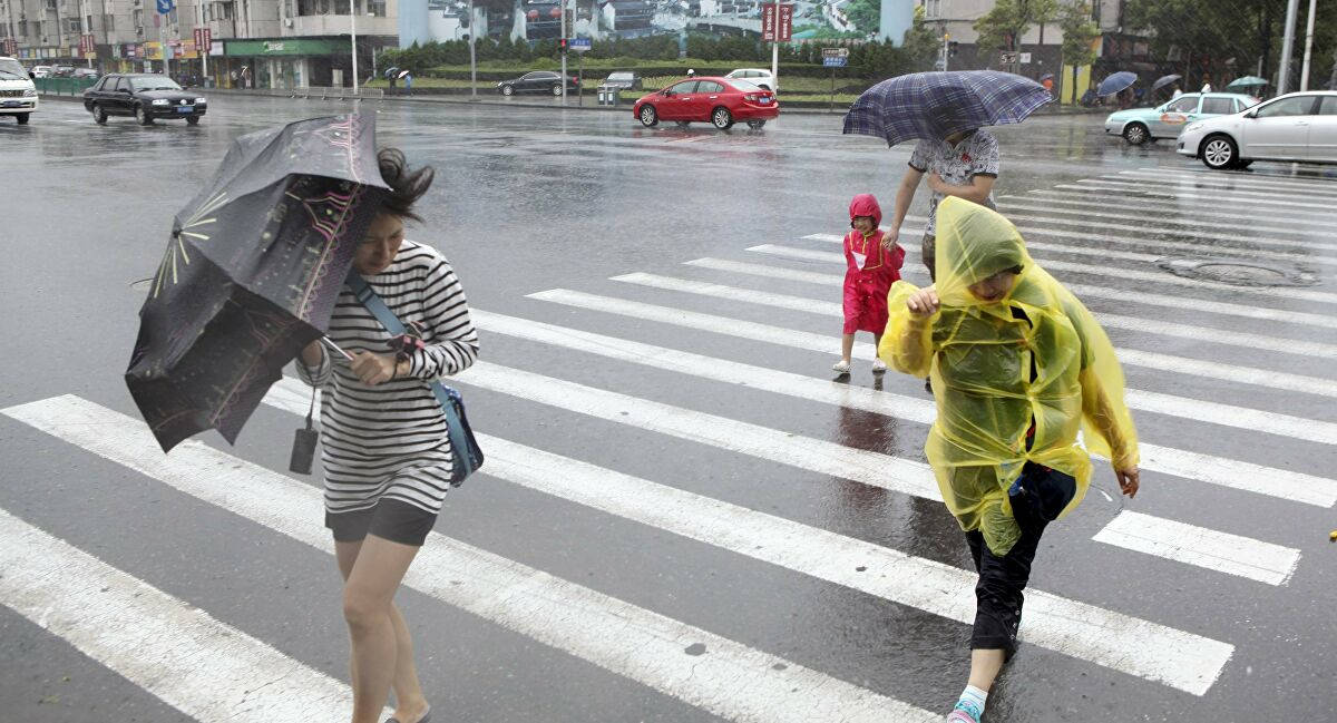pedestrians crossing the street during a tropical cyclone