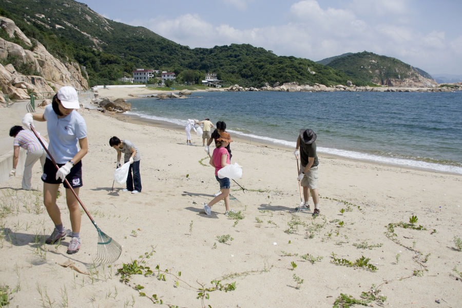 volunteers cleaning litter from a beach in hong kong