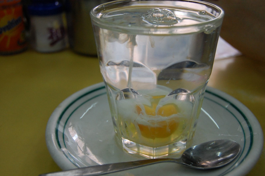 clear glass of hot water mixed with raw egg