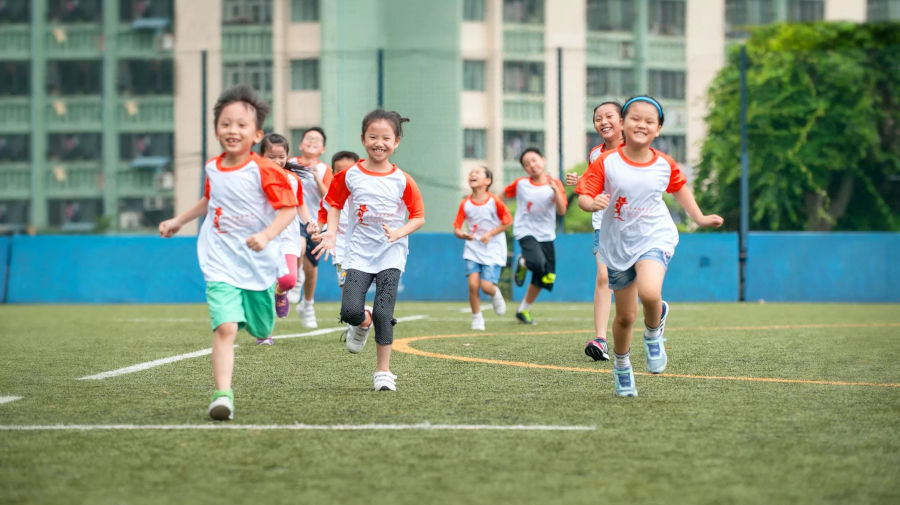 children laughing and running on a football field