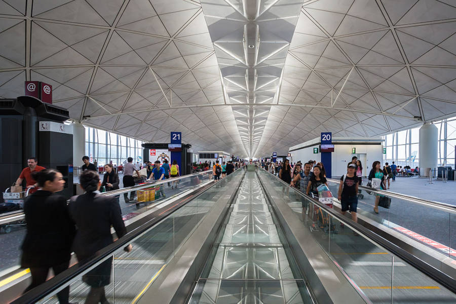 travellers on moving walkway in hong kong airport