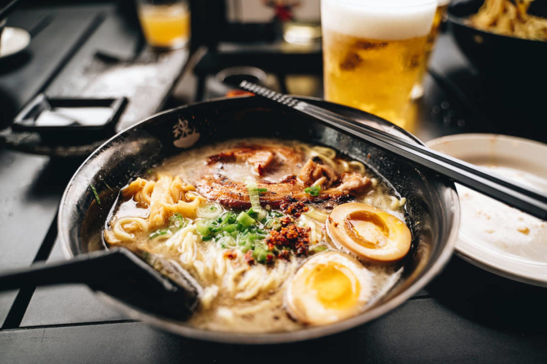 bowl of ramen with glass of beer