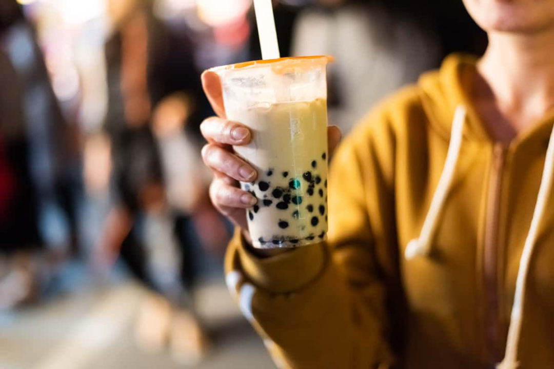 person holding plastic cup of bubble tea