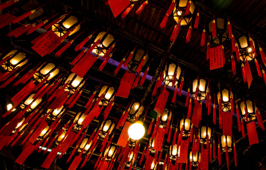 paper prayers hanging from lanterns in kwan tai temple