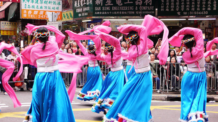 brightly costumed women dancing for tin hau festival