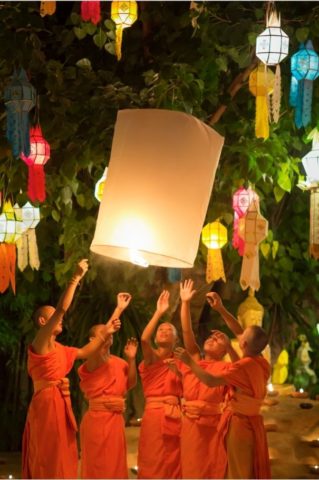 monks setting a lantern into the sky in honour of buddha