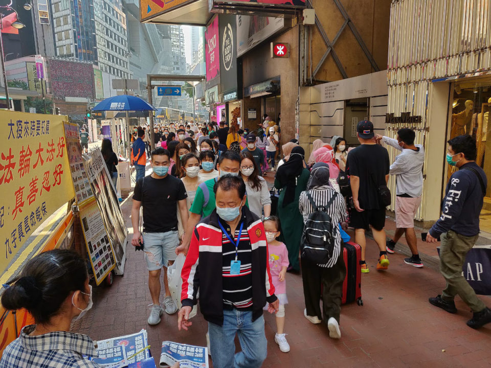 pedestrians wear masks in hong kong