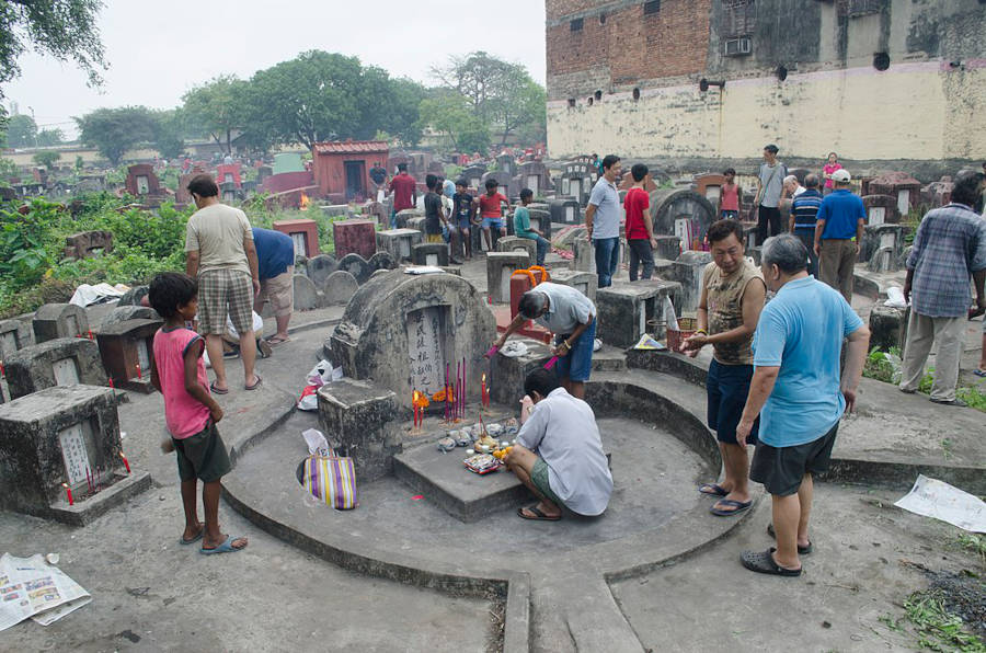 cleaning ancestors tombs and leaving food offerings on qing ming festival