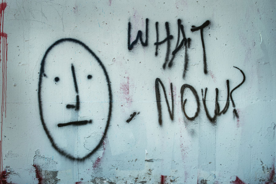 graffiti on wall saying 'what now?'
