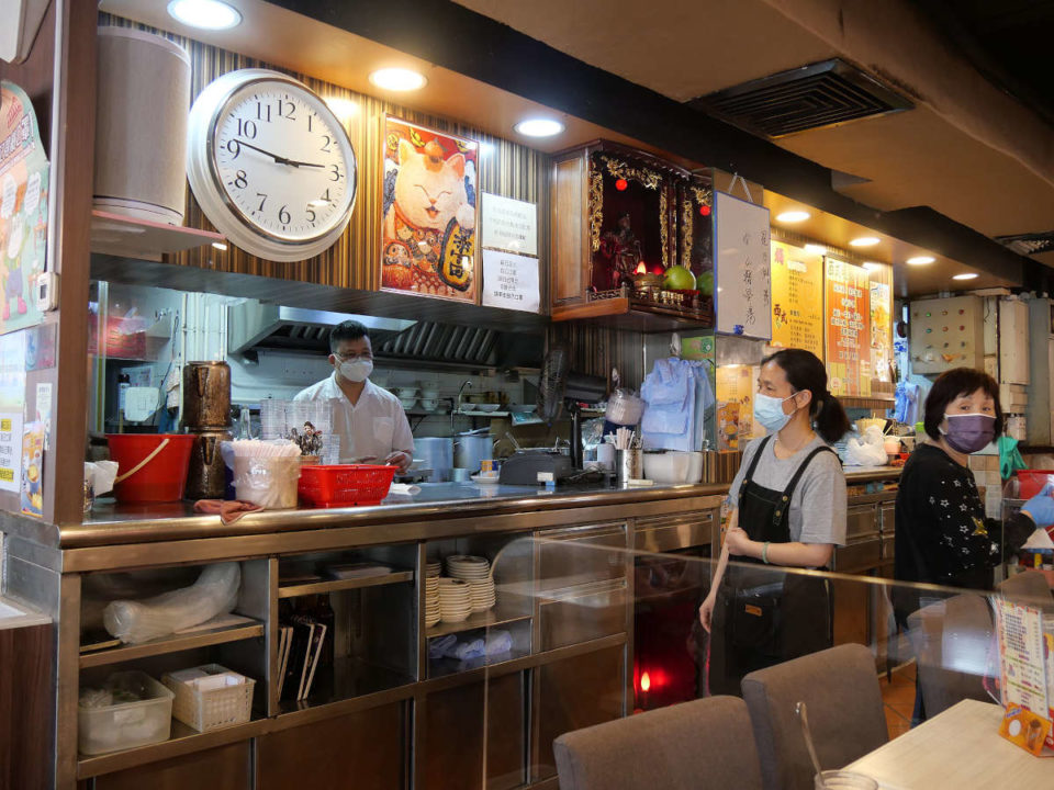 masked employees in hong kong restaurant during pandemic