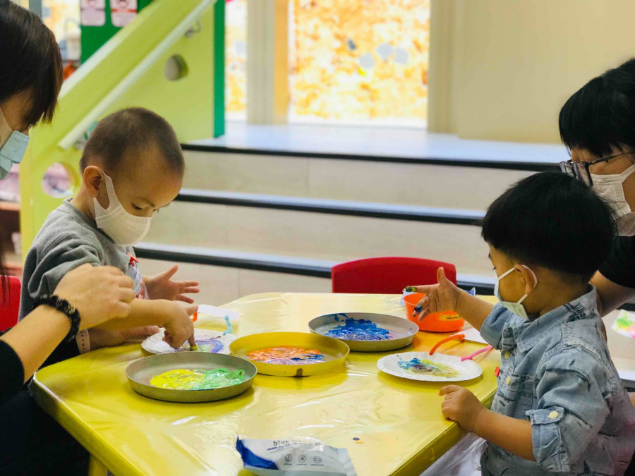 children playing with paint at pebbles playgroup