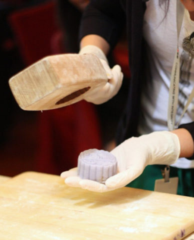 chef using wood mould to stamp mid autumn festival mooncake