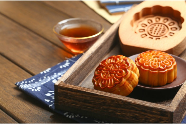 mooncakes with chinese tea and wood mould in the background