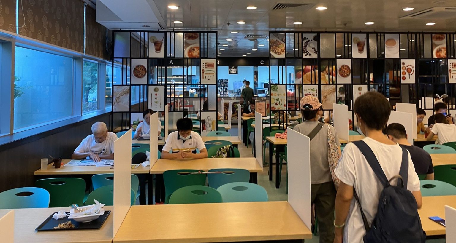 Table partitions at a Hong Kong restaurant placed as part of the city's social distancing restrictions. Some diners are wearing face masks.