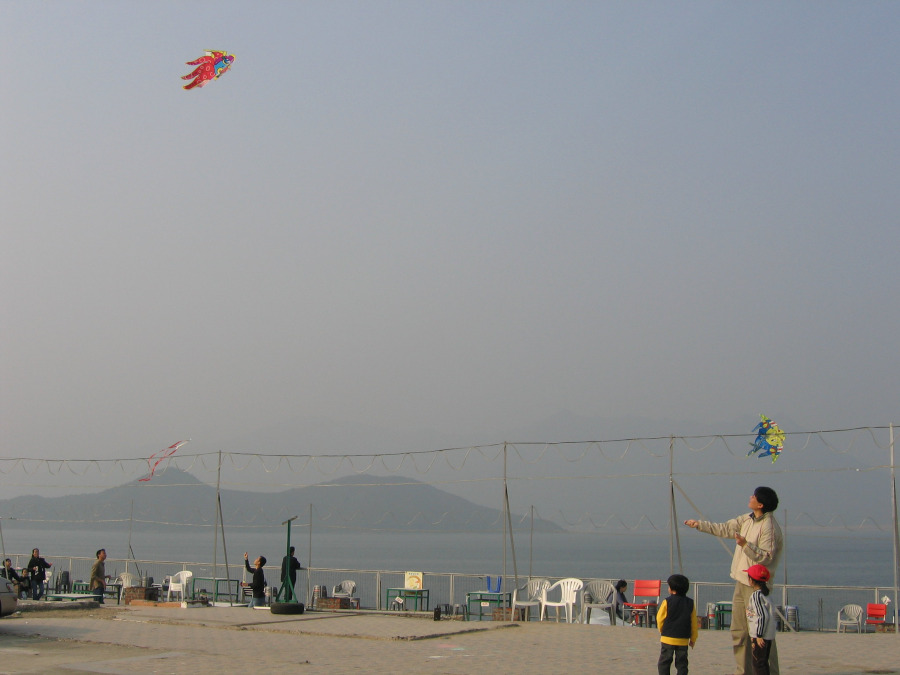 dad flying kites with kids in hong kong during chongyang festival