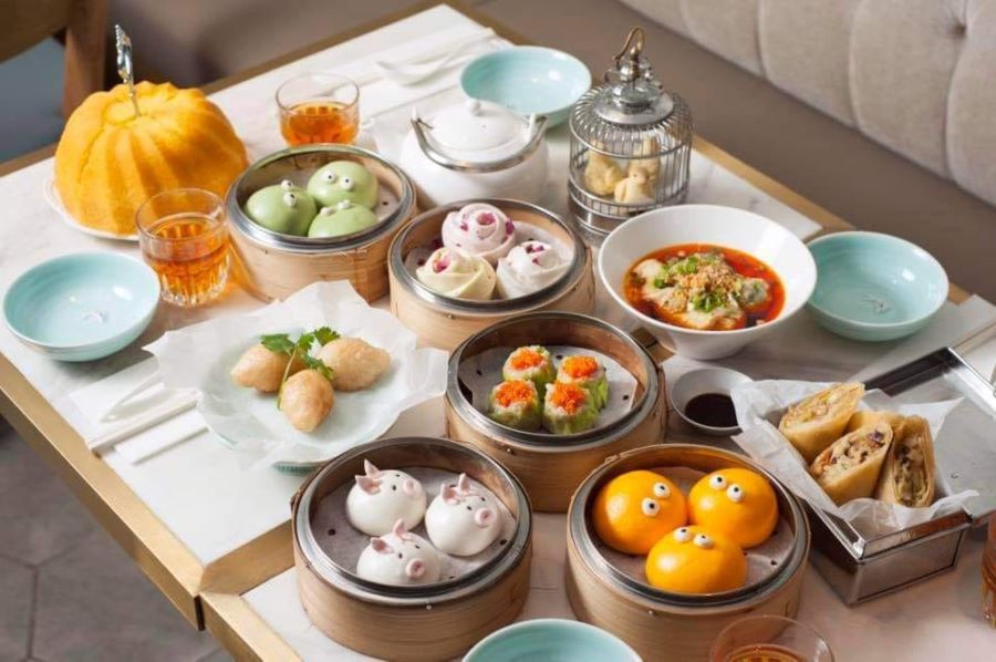 A table with an assortment of dim sum at Yum Cha. They include BBQ Piggy Buns, custard buns and the restaurant's character bao buns.