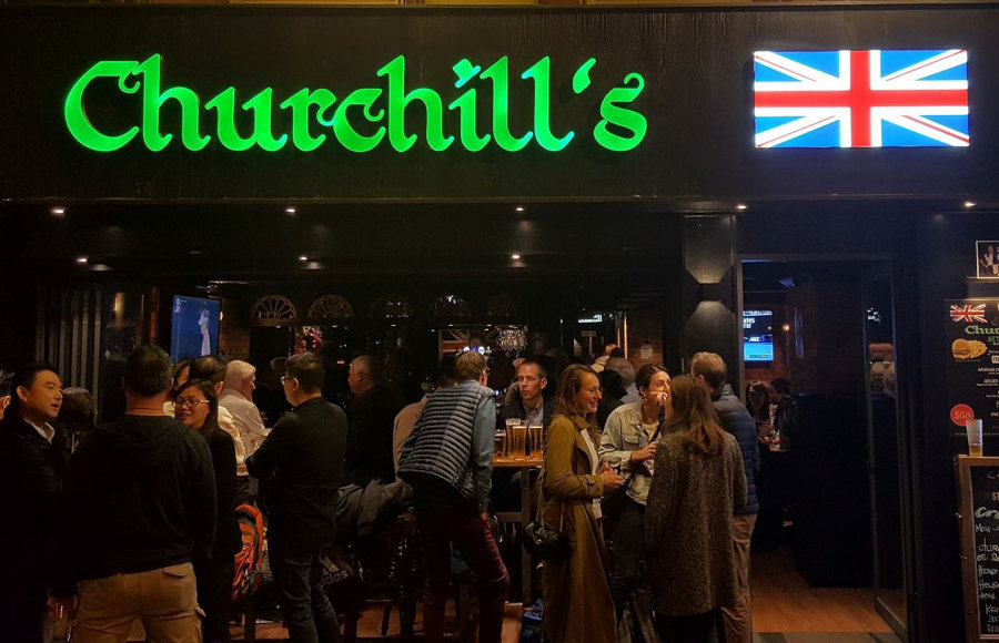 quizzers standing in open front of churchill's pub hong kong