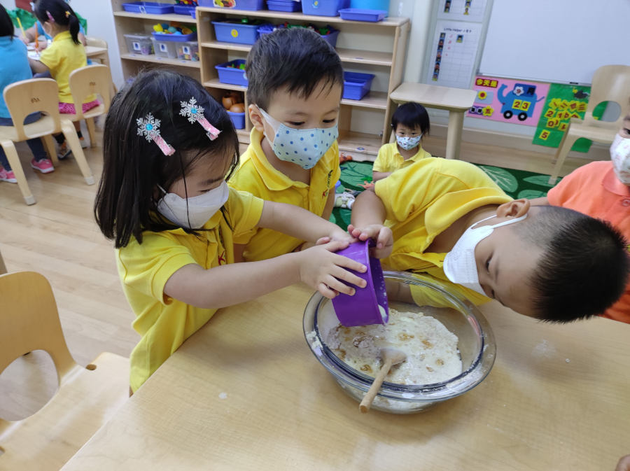 kindergarten students engaged in a sensory activity at kingston international school