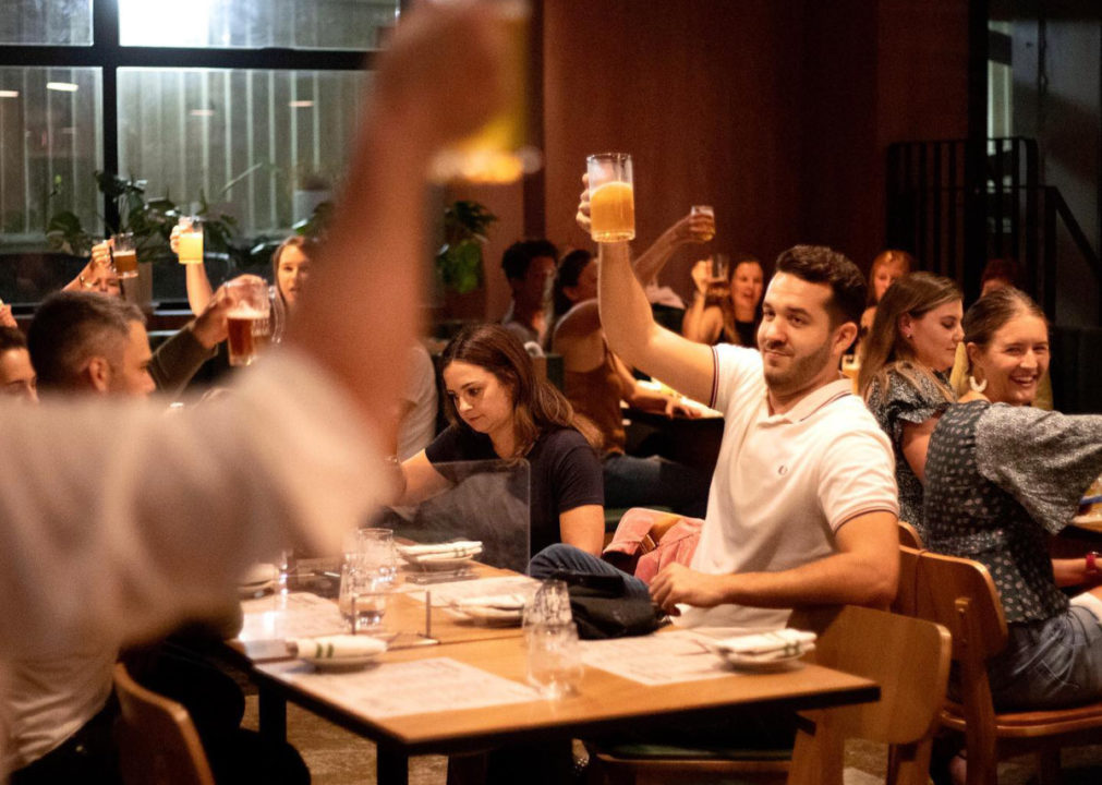 pub quizzers raising their beers for cheers at grain gastropub hong kong