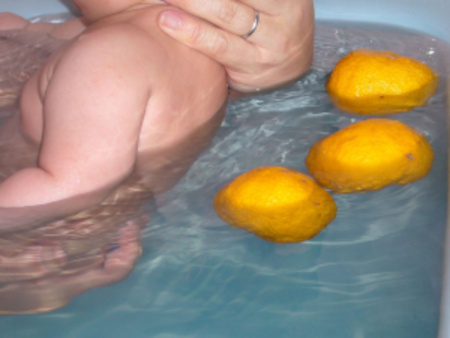 baby being bathed in citron bath for winter solstice