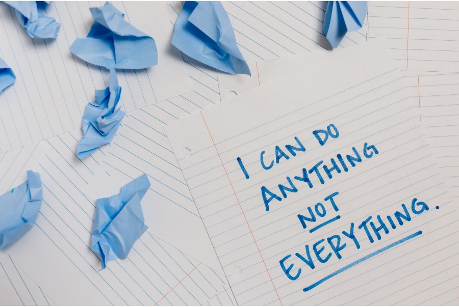 paper with 'I can do anything, not everything' written on it in blue marker