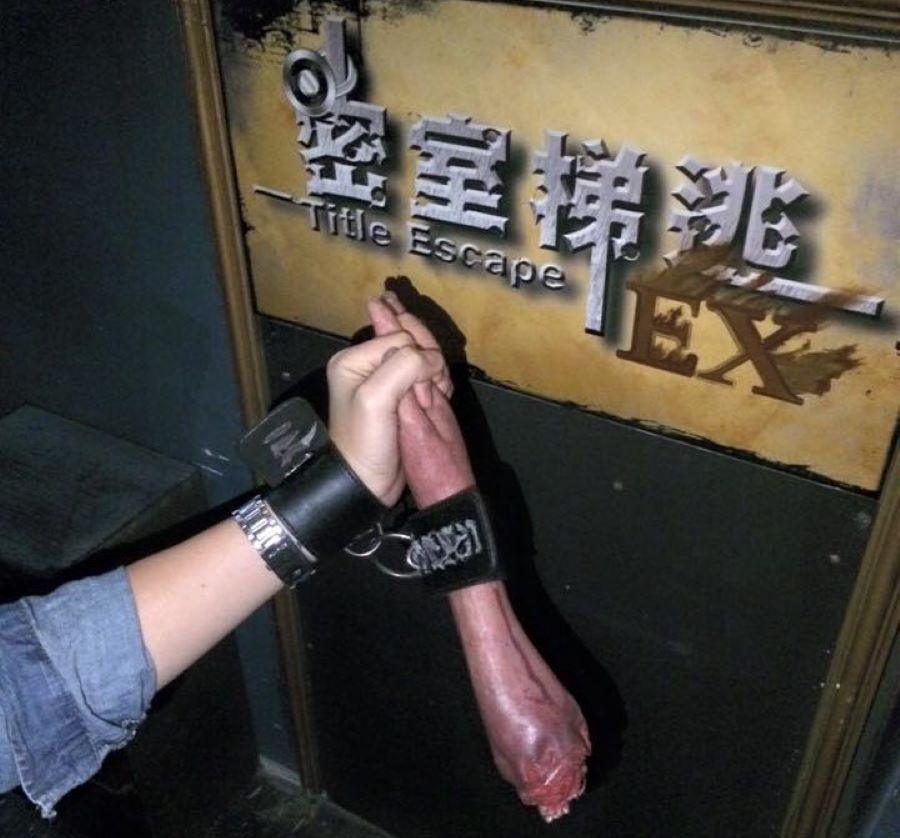 A player at Title Escape holds a fake disembodied arm.