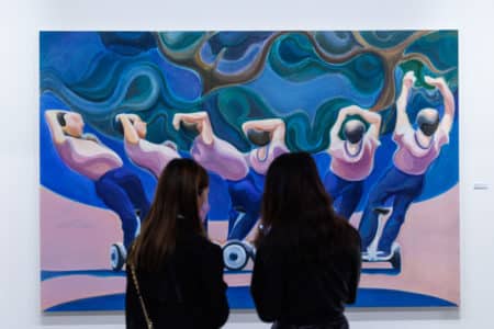 two women looking at a painting as part of art basel hong kong