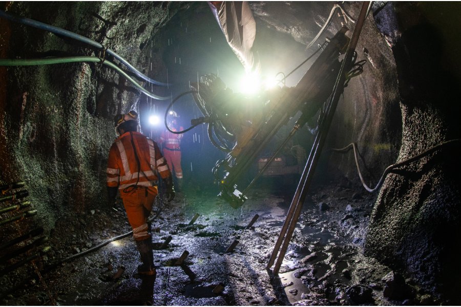 mining workers and heavy equipment inside an underground mine