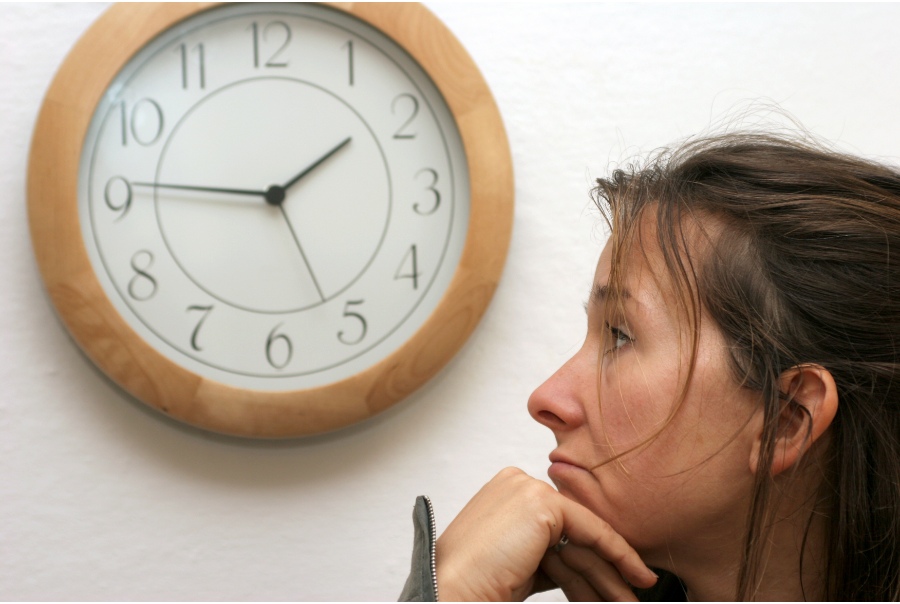 woman looking longingly at a clock