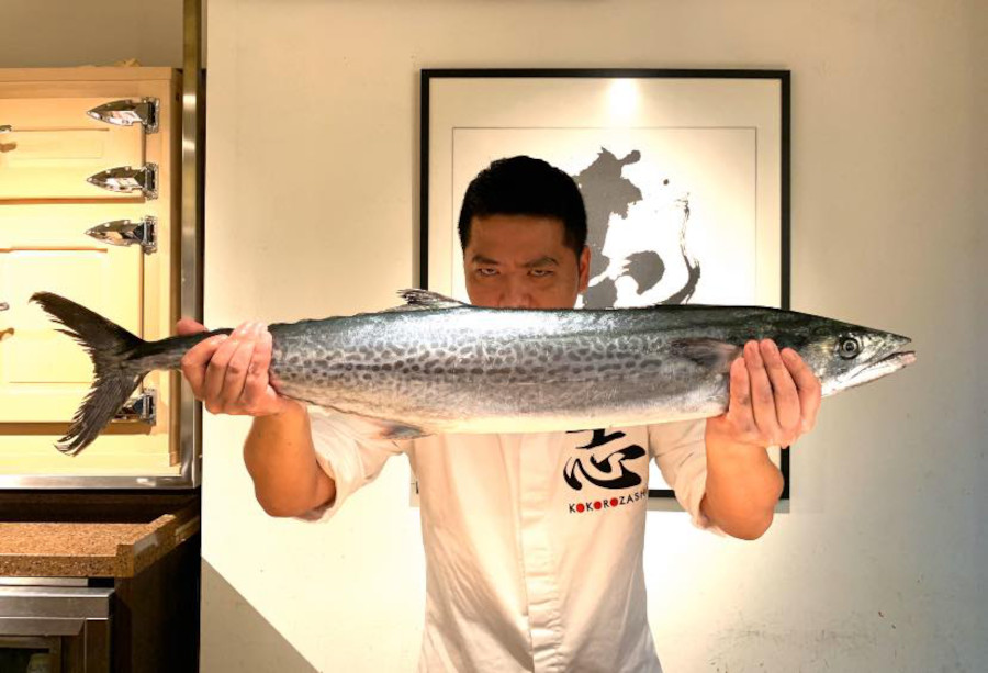 sushi chef holding a large mackerel fish at kokorozashi