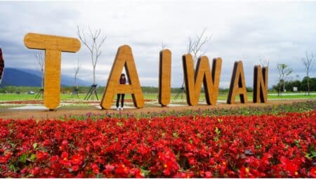 Visitors To Taiwan Can Receive NT$5000 (HK$1250) For Shopping, Accommodation From May 1 tourist posing with taiwan country name display