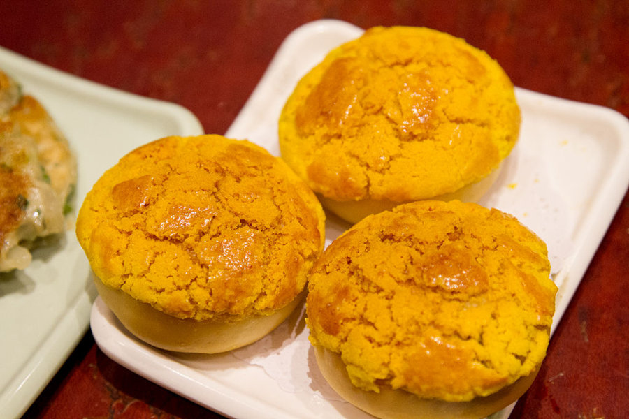 three pineapple buns on a plate in hong kong