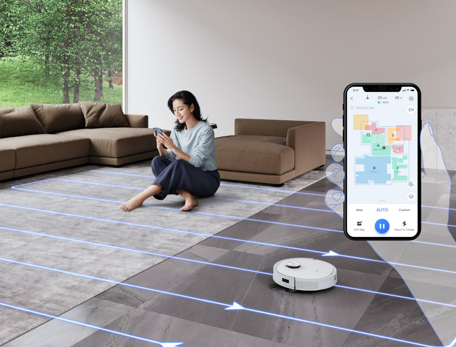 woman using ecovacs home app in her living room while the deebot robot vacuum intelligently navigates around her