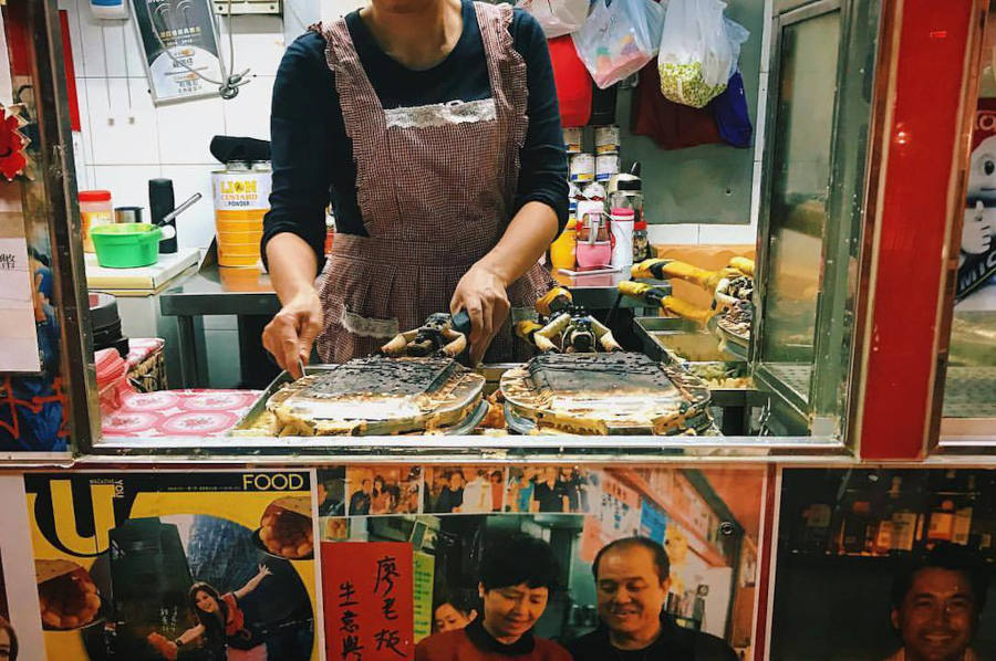 lady operating egg waffle machines at lee keung kee north point egg waffles hk