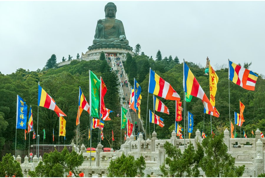 flags in front of big buddha statue hong kong