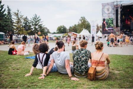 audience sitting on the grass at an outdoor concert