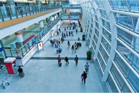 Greater Bay Airlines Offers One-Way Tickets From Hong Kong To Thailand, Taiwan & Vietnam for HK$10, Only On July 25 An overhead view of an entry hall in the Hong Kong International Airport. Several people walk up and down the hall carrying luggage or bags.