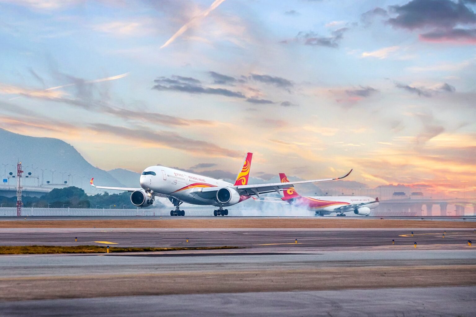Two Hong Kong Airlines flight going in opposite directions on an airport runway