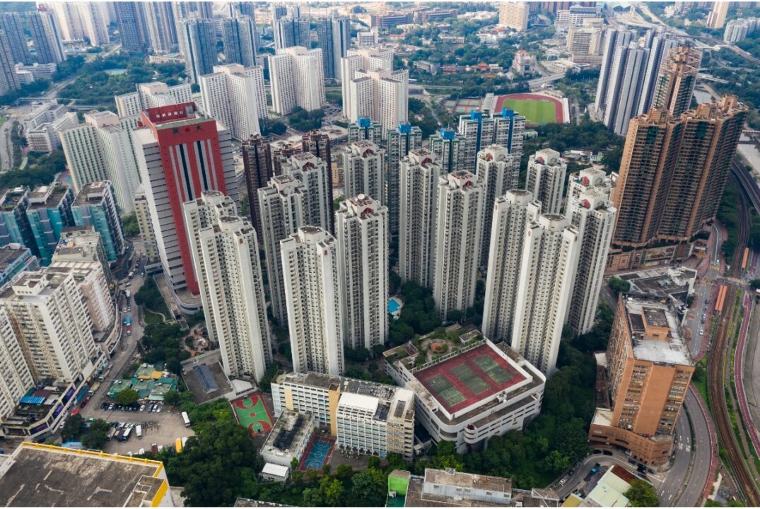 An overhead view of residential flats in Hong Kong. Most of the buildings are high-rises, with fewer lower buildings.