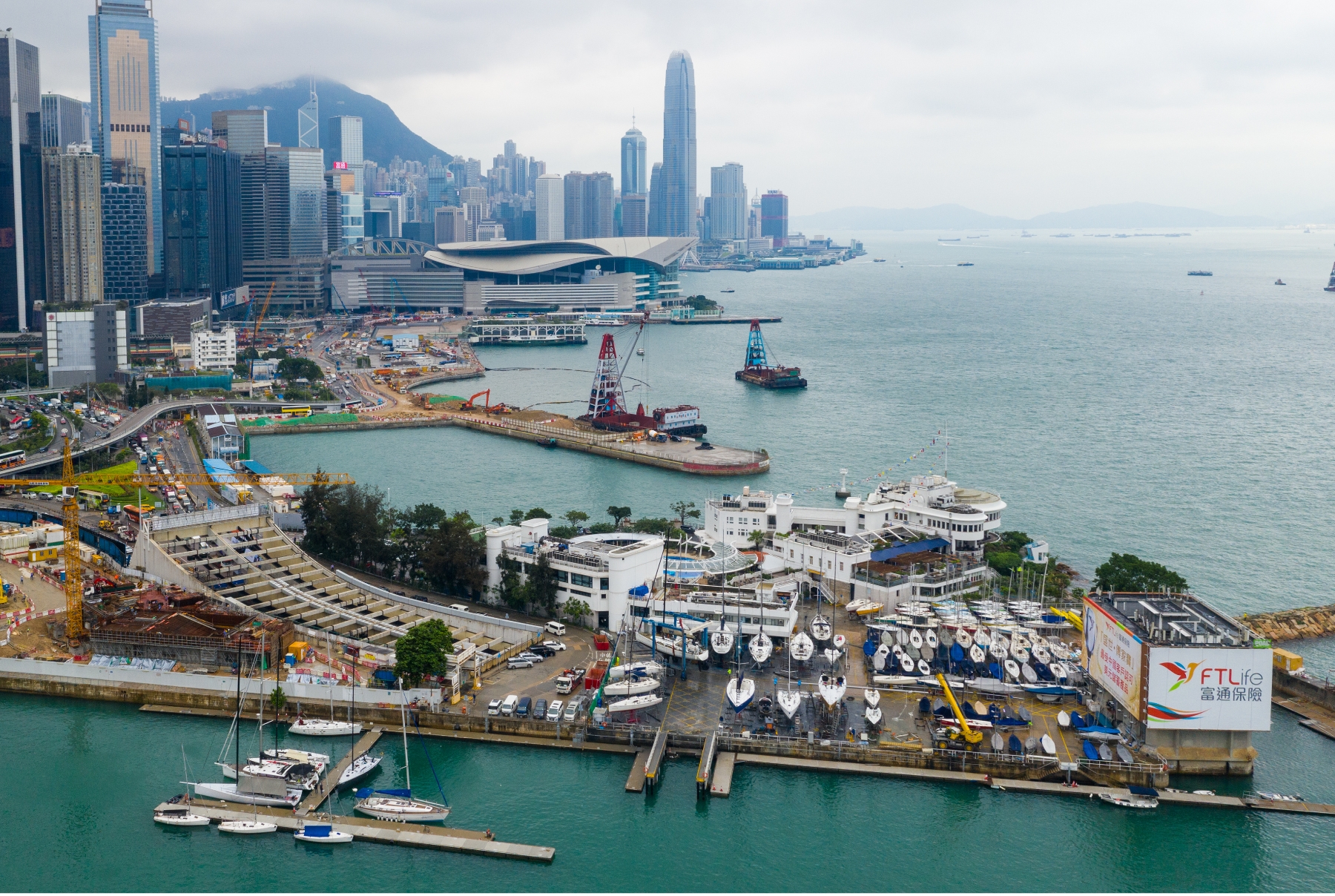 A view of the Royal Hong Kong Yacht Club in the foreground and the Hong Kong Convention and Exhibition Centre in the background.