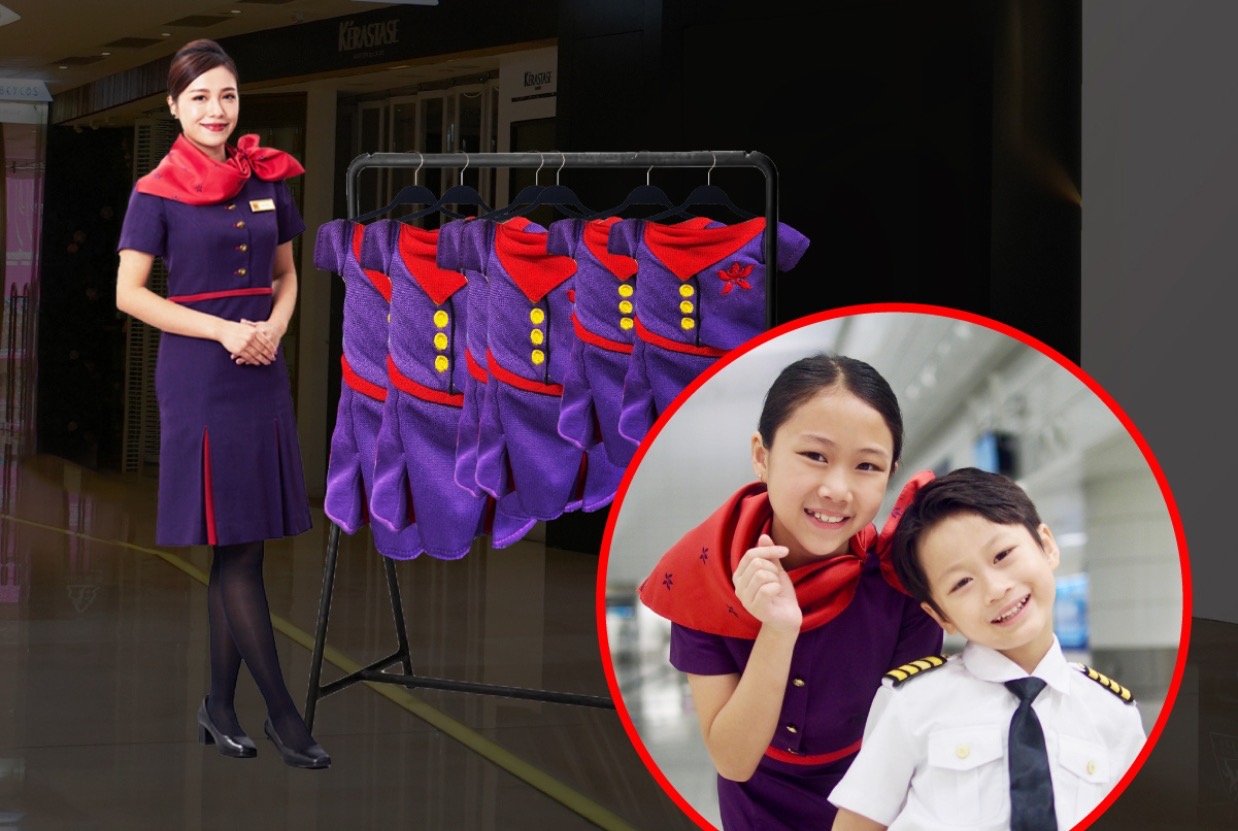 A Hong Kong Airlines flight attendant stands next to a rack of child-sized flight attendant uniforms. There is an inset picture that shows a pre-teen girl dressed up as a flight attendant and a young boy in a pilot's uniform.