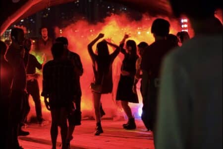 Quarryside Summer Fest: Silent Disco Party, Live Music & Workshops From August 25-27 (Free Entry) People at a silent disco dance to music they can hear through their headphones. The event is held at night, so the people are mostly in silhouette.