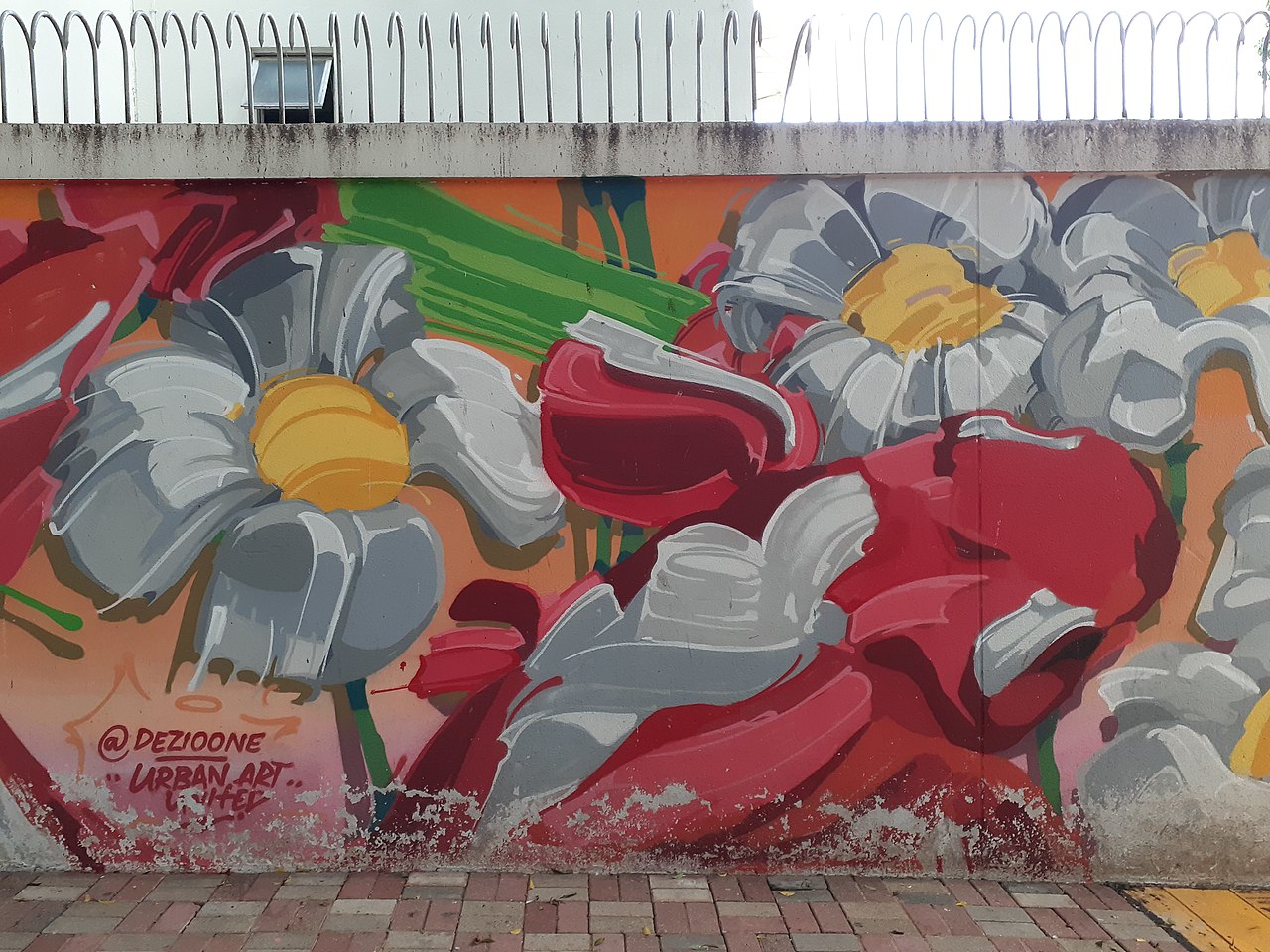 A mural showing white-petaled flowers interspersed with red and green strokes on a school wall.