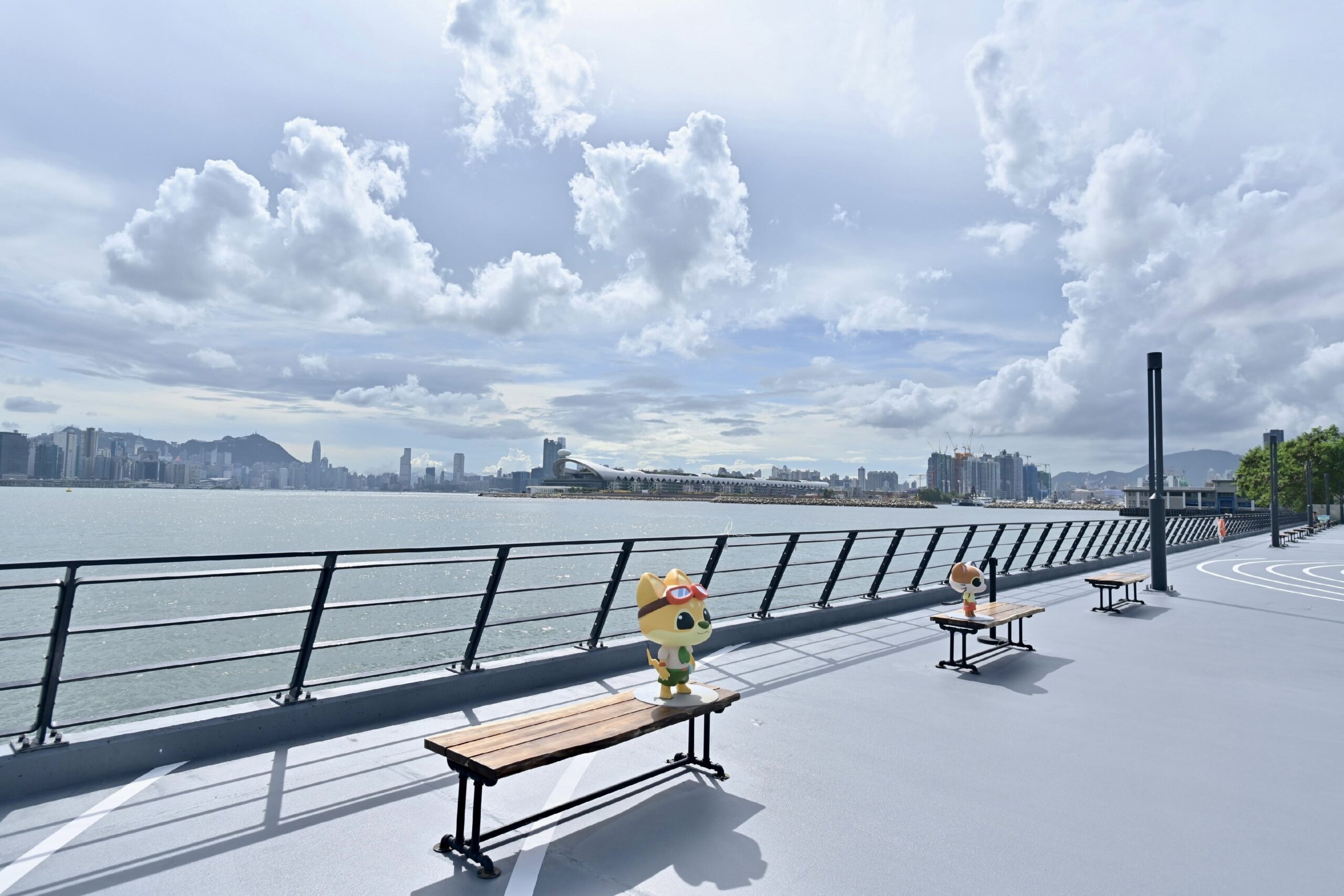 Benches on the Tsui Ping Seaside with cartoon animal figures. The walkway overlooks the Kai Tak Cruise Terminal.
