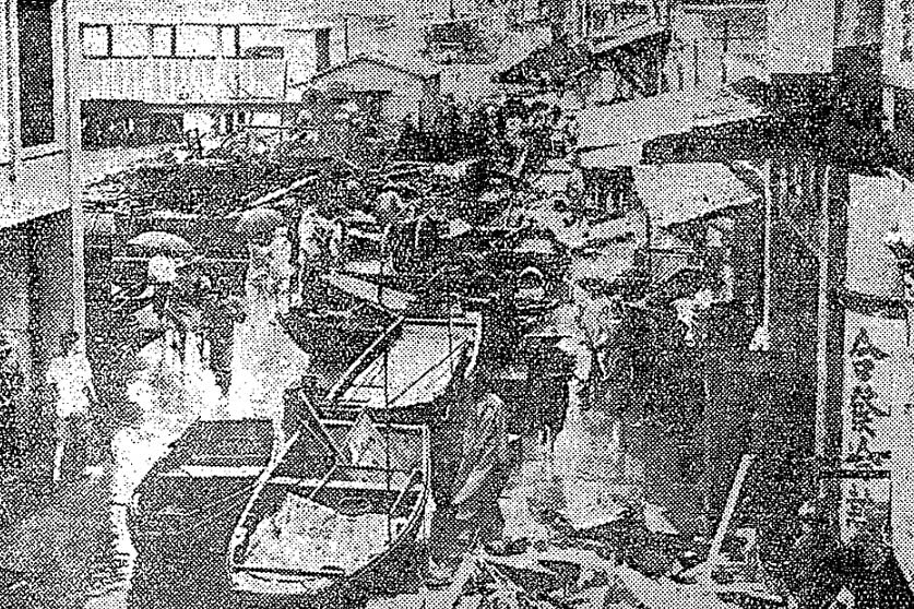 A grainy black-and-white image showing people jostling for space among boats in the streets of Hong Kong in the wake of the destruction caused by Typhoon Mary.