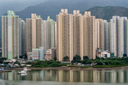 Hong Kong Home Prices Predicted To Fall By 5% After Mortgage Rates Increase a view of a block of apartments in hong kong