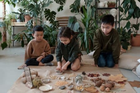 12 Fun Fall Holiday Camps In Hong Kong For 2023 three children playing with autumn foliage