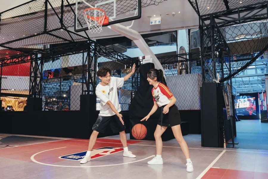 a young couple playing at the nba mini basketball court